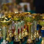Array of golden trophies on a table, reflecting victory and achievement.