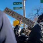 Protest at New York intersection with sign 'Rikers is a death sentence'.