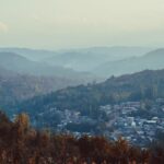 A serene view of Srinagar's mist-covered hills and lush landscape, showcasing a tranquil townscape.