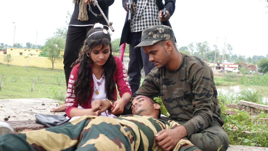 A group of people providing first aid to an injured soldier in an outdoor setting.