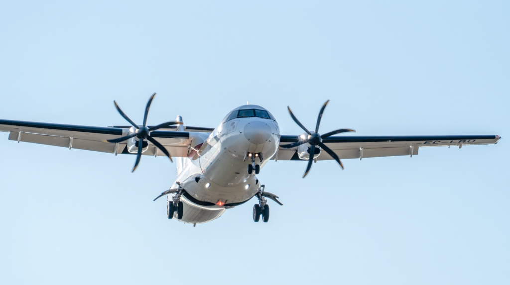 Close-up of an ATR 72 aircraft landing in Manises, Valencia, clear sky background.