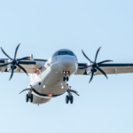 Close-up of an ATR 72 aircraft landing in Manises, Valencia, clear sky background.