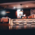 Warm-lit cafe interior showcasing pastries and beverages, creating a cozy atmosphere in Shoolagiri, India.