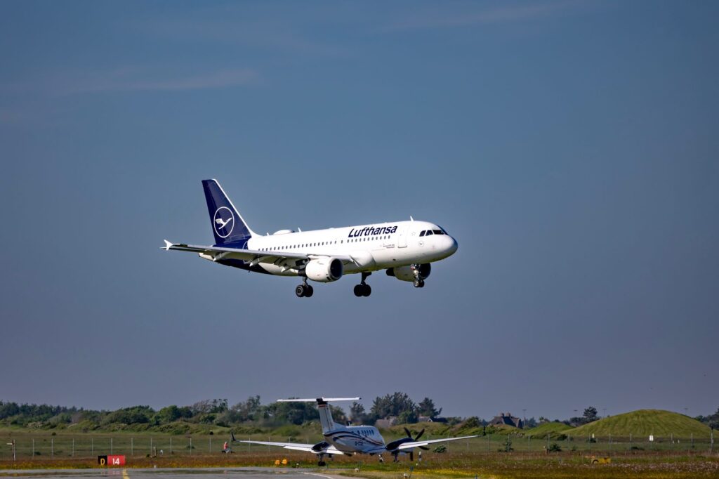 Lufthansa aircraft approaching for landing at Sylt Airport on a clear day.
