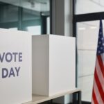 Voting booth setup with American flag, symbolizing election day.