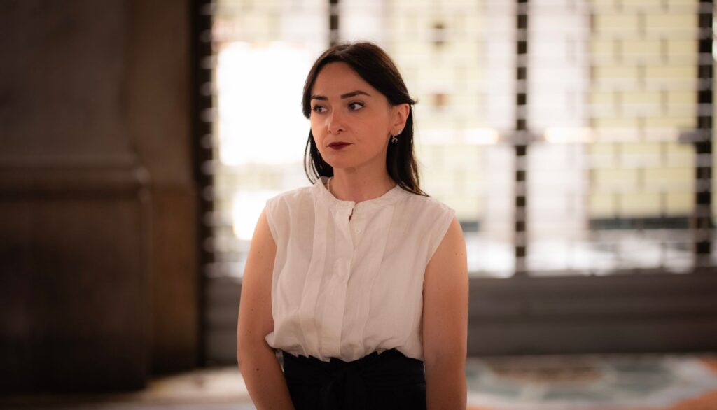 Portrait of an elegant young woman posing indoors with soft lighting in Milan, Italy.