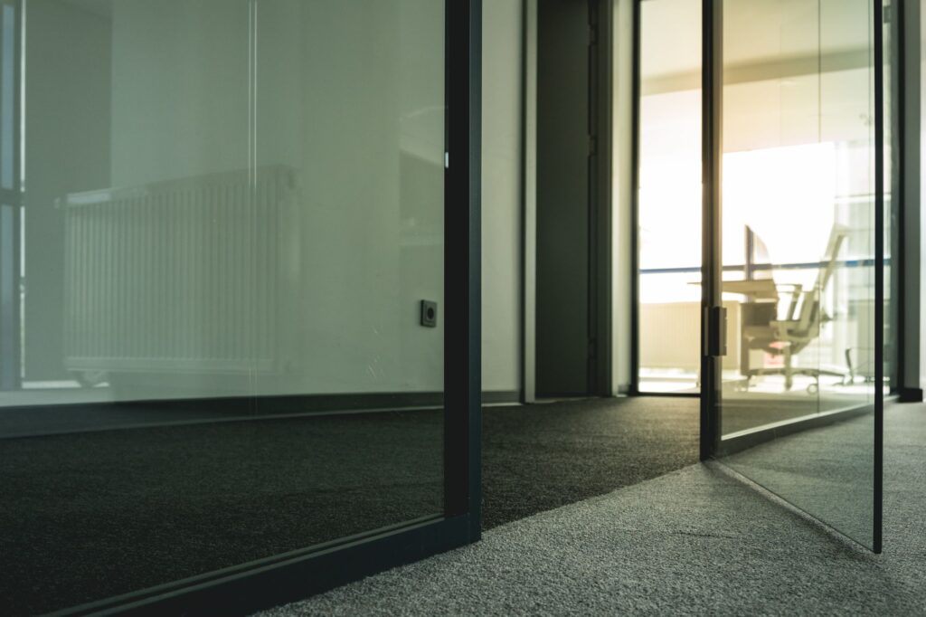 Contemporary office space with glass doors and minimalist design elements.