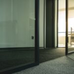 Contemporary office space with glass doors and minimalist design elements.