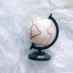 A globe wrapped in plastic symbolizes environmental issues and the need for sustainability.