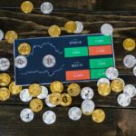 Bitcoin coins scattered around a stock chart on a dark wooden table, symbolizing cryptocurrency investment.