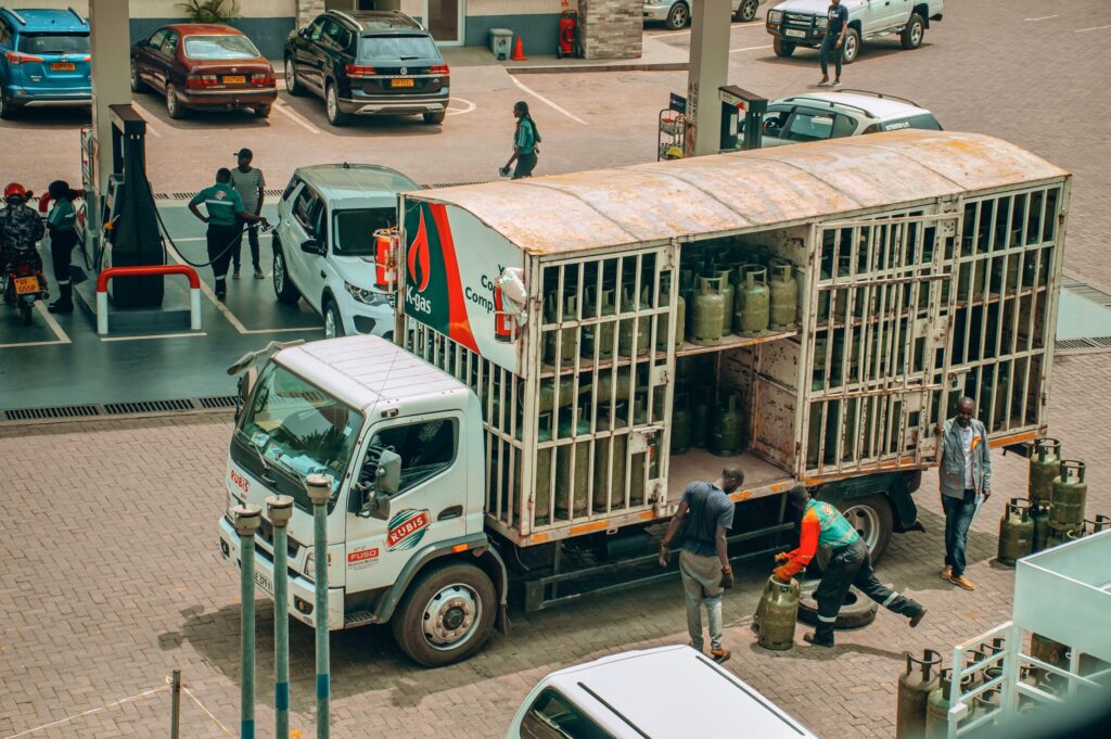 An LPG gas truck making a delivery at a busy urban station.