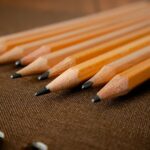 A detailed view of sharpened wooden pencils placed on a textured fabric background, showing artistry and precision.