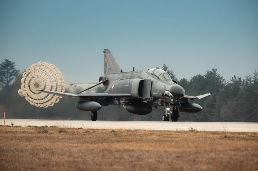 Turkish Air Force jet fighter landing with parachute deployed on runway in Türkiye.