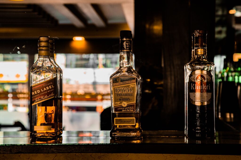 Close-up of whiskey bottles on a bar counter, creating a cozy ambiance in Pokhara, Nepal.
