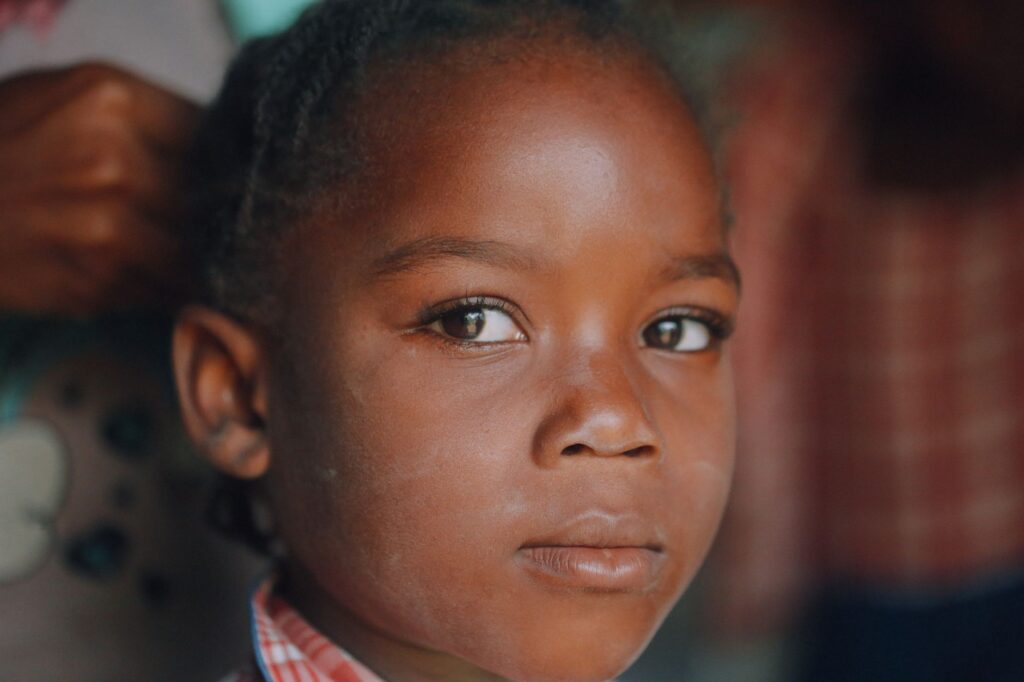 Close-up portrait of a young Haitian girl with expressive eyes and calm demeanor.