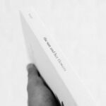 Black and white photo of a hand holding a book, emphasizing simplicity and elegance.