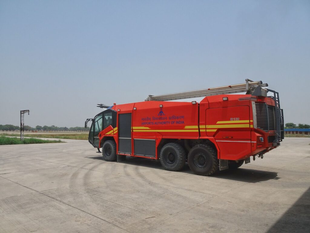 Red airport fire truck on an airstrip, operated by Airports Authority of India.