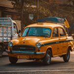 Classic yellow taxi in Kolkata, India, showcasing bustling city life and vintage charm.
