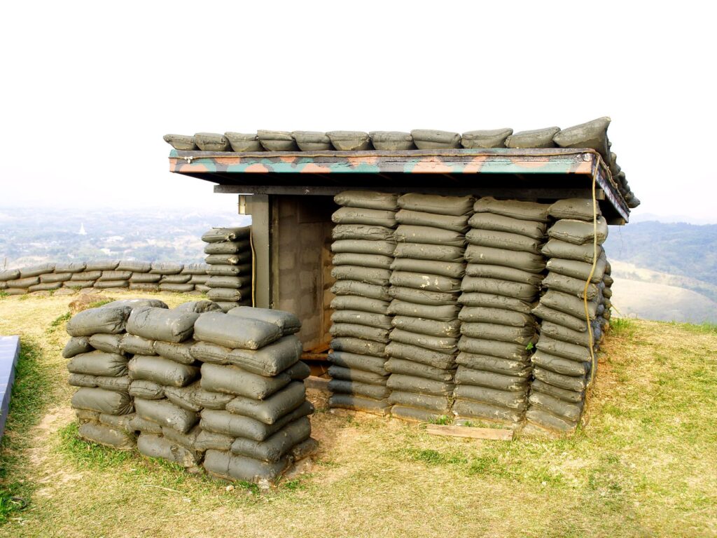 A sandbag bunker structure on a hill, used for military protection.