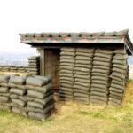 A sandbag bunker structure on a hill, used for military protection.