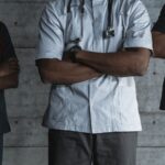 Group of medical professionals standing confidently with folded arms in uniform.