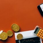 Flat lay showing coins, calculator, and charts on a red background for financial analysis and business concepts.