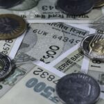 Detailed view of Indian rupee banknotes and coins, showcasing currency variety.