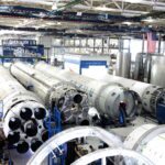 View of a spacecraft assembly line with rockets in a spacious hangar.