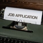Close-up of a vintage typewriter with a job application paper inserted.