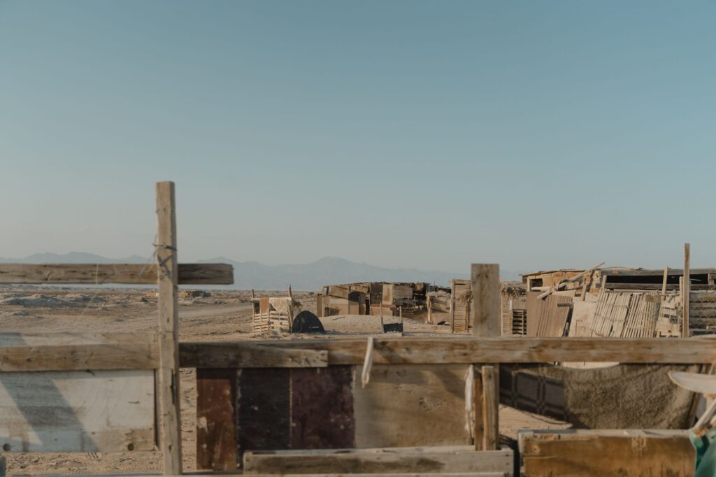 Rustic wooden structures in a desert landscape under a clear sky.