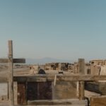 Rustic wooden structures in a desert landscape under a clear sky.