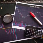 Stock report with charts, calculator, and magnifying glass for financial analysis.