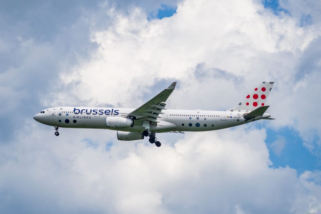Brussels Airlines Airbus A330 flying high among white clouds, showcasing travel and aviation.