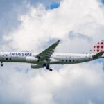 Brussels Airlines Airbus A330 flying high among white clouds, showcasing travel and aviation.