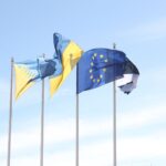 European Union and Estonian flags wave under a clear blue sky, symbolizing unity and harmony.
