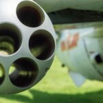 Detailed close-up of an aircraft's gun barrel with blurred background.