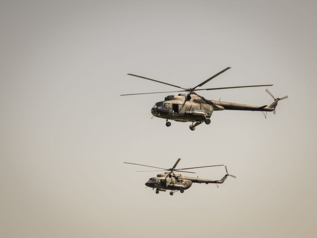 Two military helicopters flying at low altitude in clear sky over Beograd, Serbia.