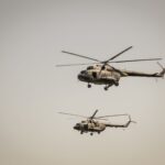 Two military helicopters flying at low altitude in clear sky over Beograd, Serbia.