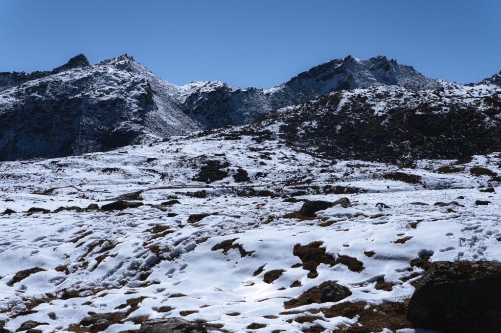 A breathtaking view of snow-covered mountains in Tawang on a sunny winter day.
