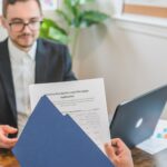 Mortgage broker and client discussing loan application with documents on table.