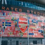 Vibrant wall art at Emirates Stadium featuring Arsenal flags and crest in London, UK.