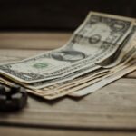 Close-up of US dollar bills on a wooden table, representing finance and commerce.