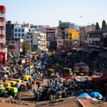 Bustling street scene in Bengaluru, India with colorful vehicles and vibrant market activity.