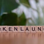 Scrabble tiles spelling 'Token Launch' on a vibrant green background.