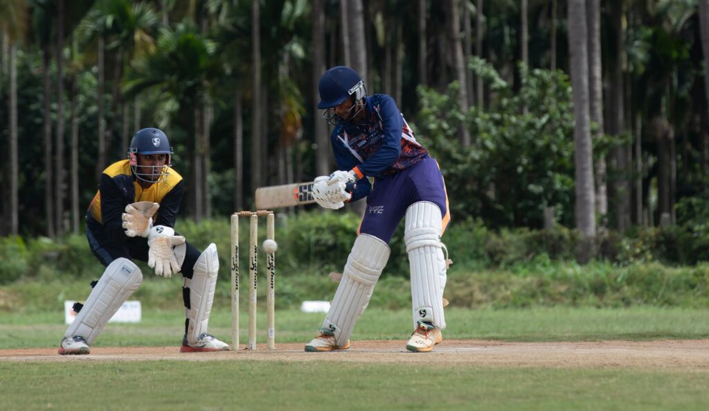 Two cricketers engaged in a match, showcasing skills on a sunny day.
