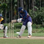 Two cricketers engaged in a match, showcasing skills on a sunny day.