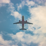 An Air India airplane flies overhead against a backdrop of blue skies and fluffy clouds in New Delhi.