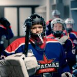Young ice hockey players geared up in dressing room, ready for game. Team spirit and readiness.