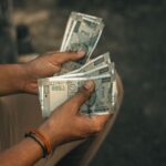 Close-up of hands holding multiple 500 Indian Rupee notes, representing wealth and financial transactions.