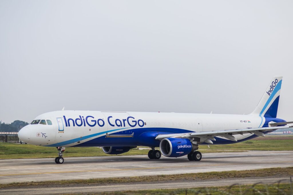 Side view of an IndiGo Cargo airplane on an airport runway during daytime.
